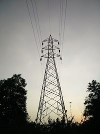 Low angle view of silhouette electricity pylon against sky at sunset