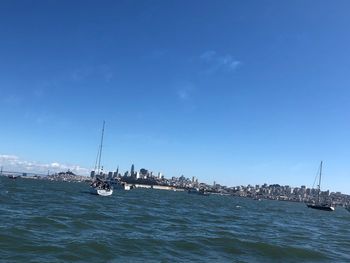 Sailboats in sea against sky