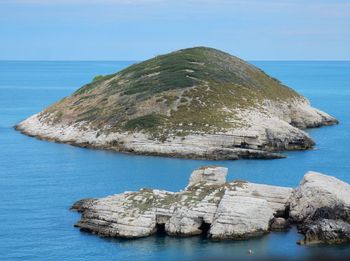 Scenic view of rock formation in sea against clear sky