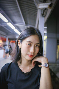 Portrait of young woman at railroad station platform