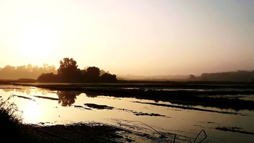 Scenic view of lake against sky during sunset