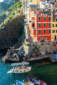 Costumed bathers on boats and on the rocks in riomaggiore terre in liguria, italy