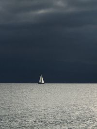 Sailboat sailing on sea against sky