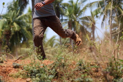 Low section of man jumping on field