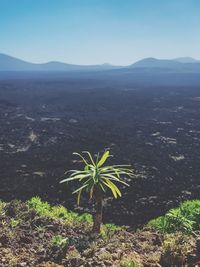 High angle view of land and mountains against clear sky