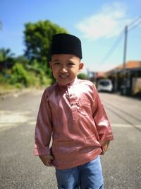 Portrait of smiling boy standing on road