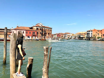 Buildings by sea against clear sky