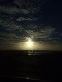 Scenic view of sea against cloudy sky at sunset