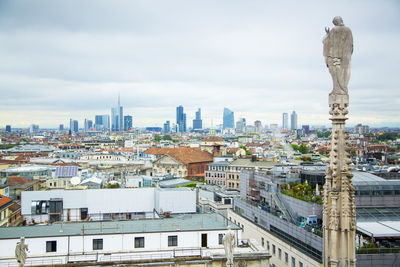 View of cityscape against cloudy sky