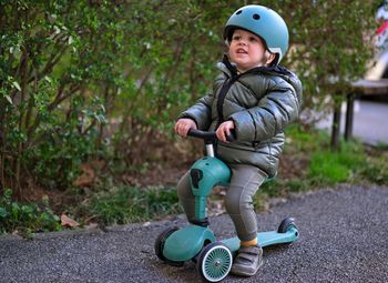 Little toddler on scooter in a park