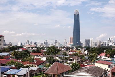 Buildings in city against cloudy sky