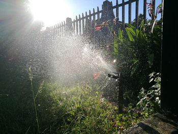 Scenic view of waterfall against sky on sunny day