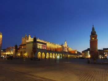 Main market square with gothic cloth hall sukiennice and town hall in krakow by night