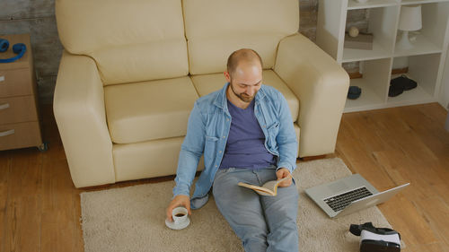 Full length of man using mobile phone at home