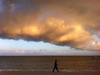 Side view of silhouette man walking on beach