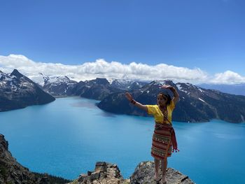 Full length of woman standing against lake and sky
