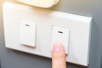 Cropped hand pressing light switch