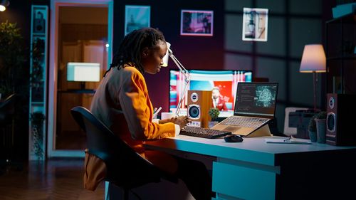 Businesswoman using laptop while sitting on table