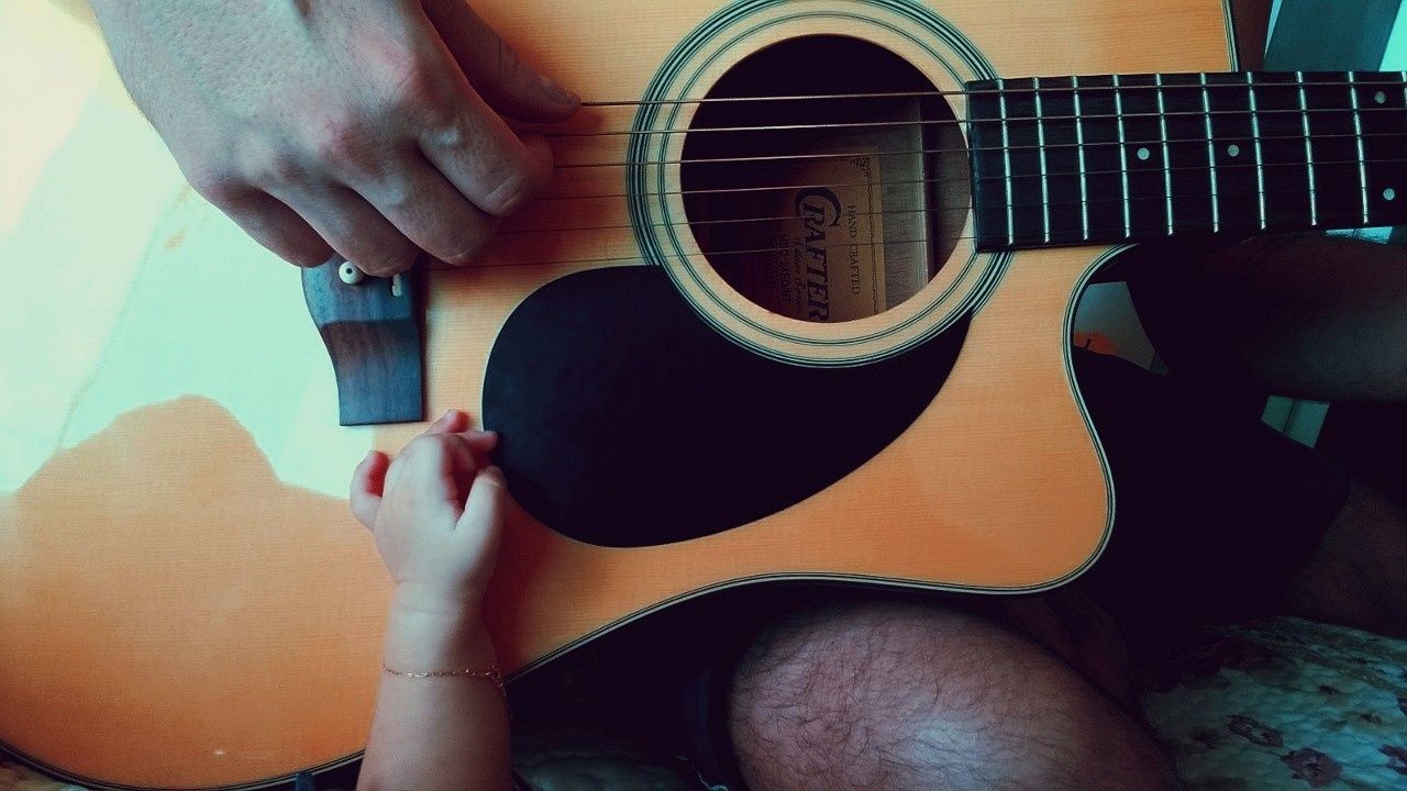 real people, one person, string instrument, guitar, musical instrument, music, indoors, human body part, lifestyles, sitting, arts culture and entertainment, holding, musical equipment, human leg, women, body part, adult, playing, low section, acoustic guitar, plucking an instrument, shorts