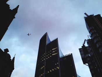 Low angle view of airplane flying over city