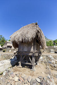 Old hut on rock against clear blue sky