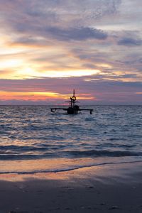 Silhouette boat sailing in sea against sky during sunset