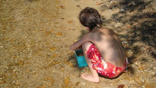 Rear view of woman sitting in water