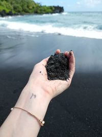 Midsection of person holding ice cream on land