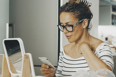 Young woman using mobile phone at home