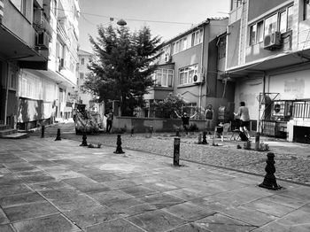 People on sidewalk by buildings in city