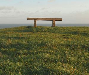 Scenic view of grassy field against cloudy sky