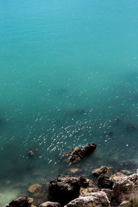 Rock formation by sea against sky 