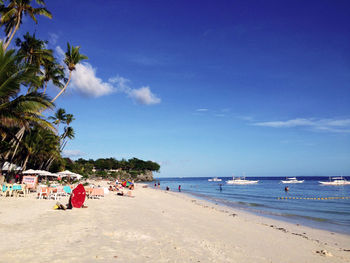 People at beach against sky