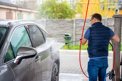 Side view of man holding car