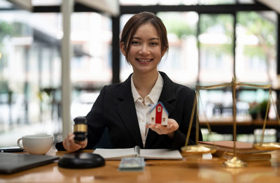 Portrait of businesswoman using mobile phone in office