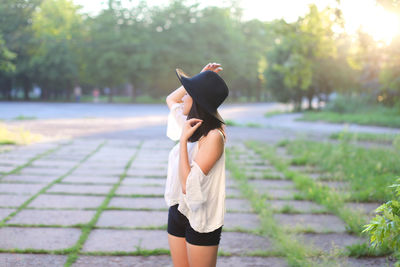 Full length of woman standing on footpath