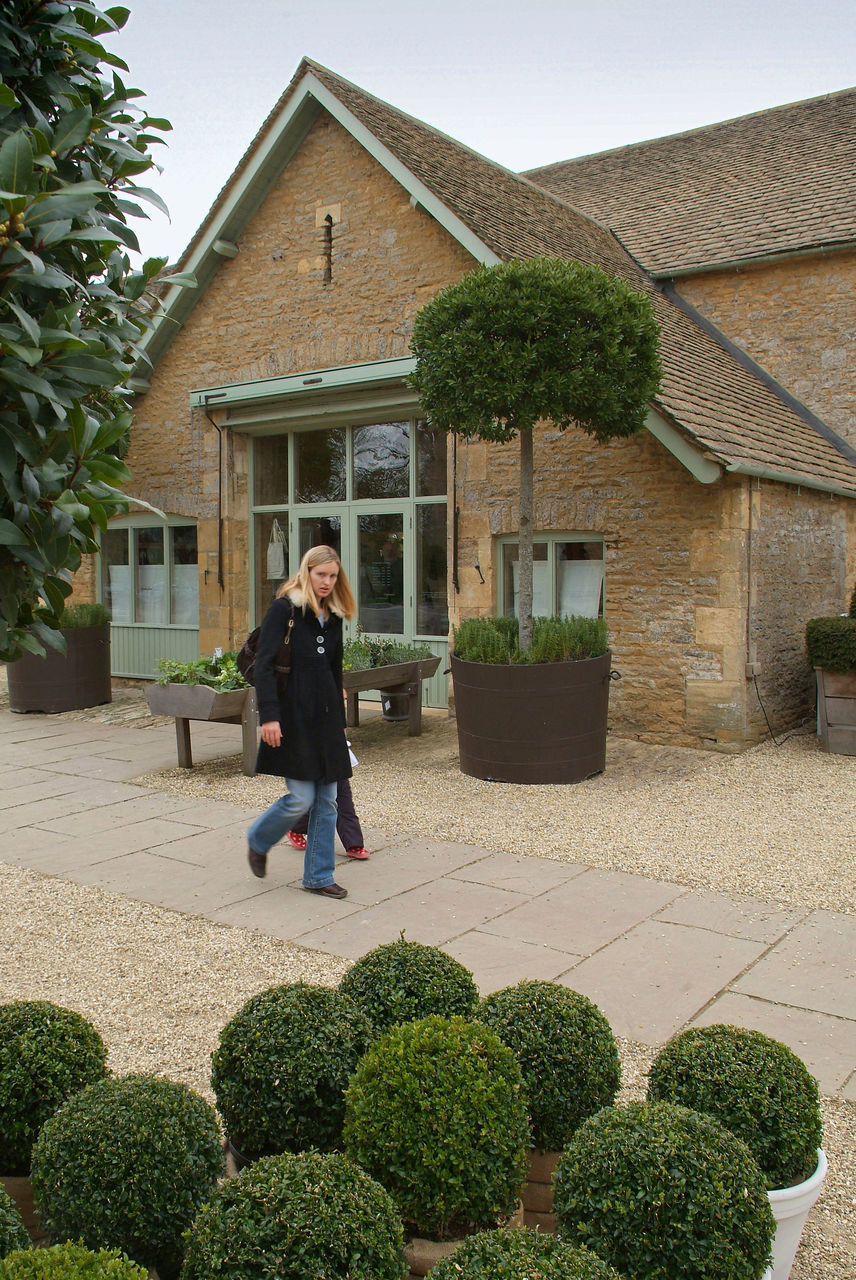 WOMAN STANDING BY HOUSE