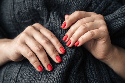 Midsection of woman with red painted nails