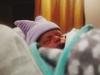 Close-up of baby sleeping on bed