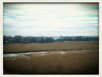 Scenic view of landscape against cloudy sky