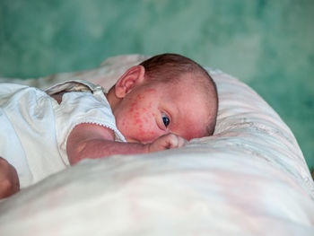 Portrait of cute baby lying down on bed