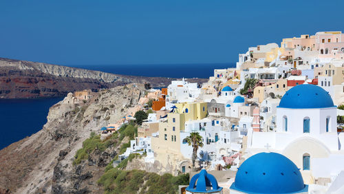 Panoramic view of sea and buildings against clear blue sky