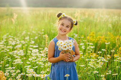 Cute smiling little girl with a bouquet of daisies