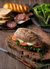 Hamburger made by whole wheat bread baked with ham, lettuce, tomato, pork sausage and cheese.