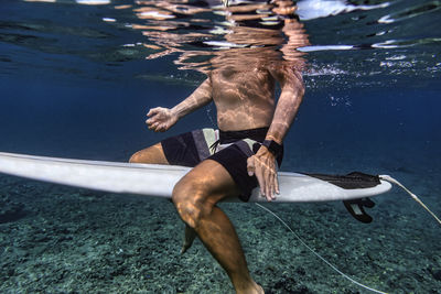 Full length of shirtless man in swimming pool