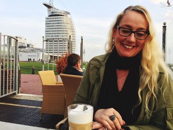 Portrait of smiling young woman sitting outdoors