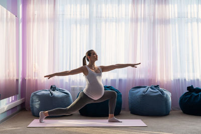 Side view of woman exercising in gym