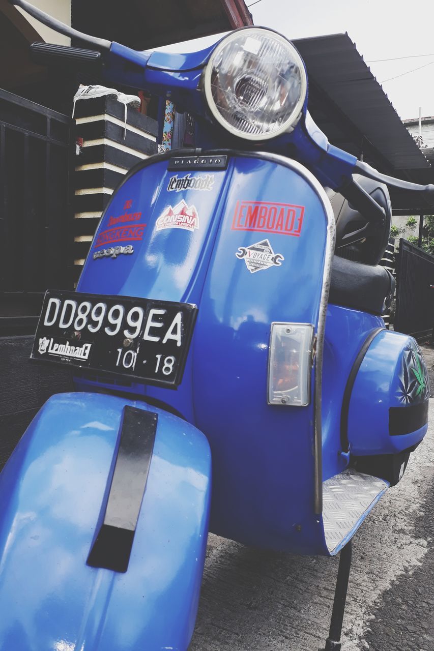 CLOSE-UP OF BLUE VINTAGE CAR ON ROAD