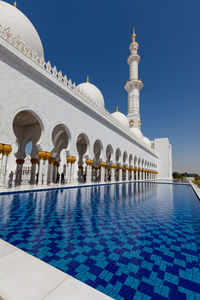 View of swimming pool by building against clear sky