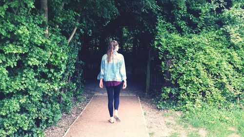 Full length of woman standing by tree